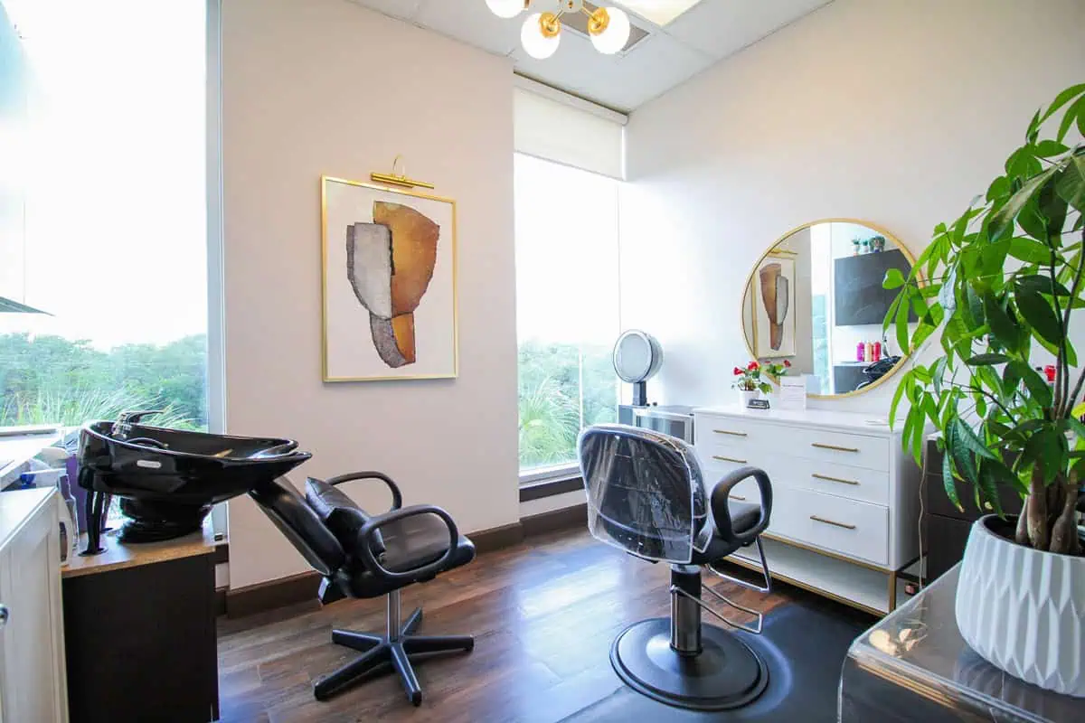 Beauty salon franchise interior with styling chair and vanity mirror.
